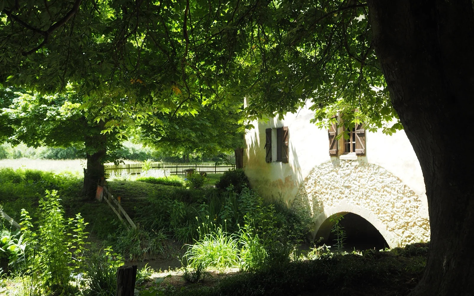 The mill’s stone arch over the water, in the shade of chestnut trees